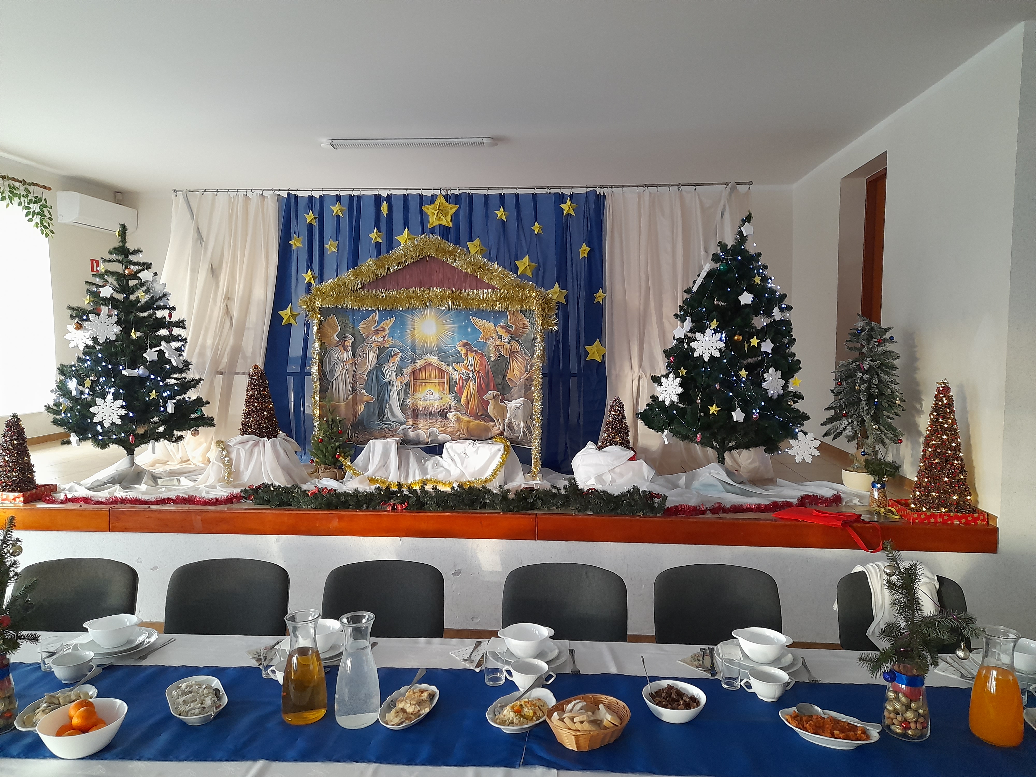 Świąteczna dekoracja stołu. Na scenie stajenka i&nbsp;choinki