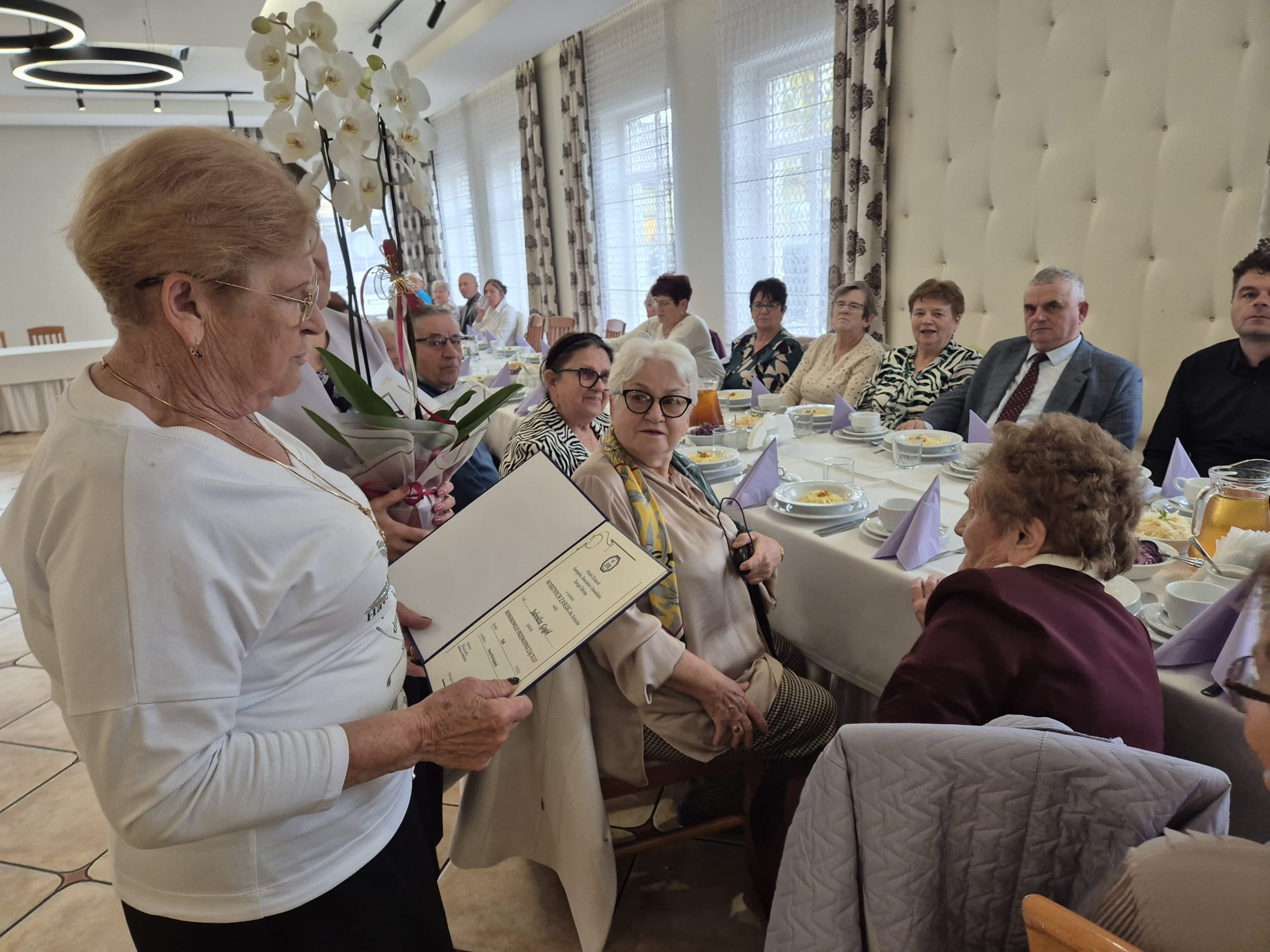 Pani w&nbsp;jasnym sweterku składa życzenia