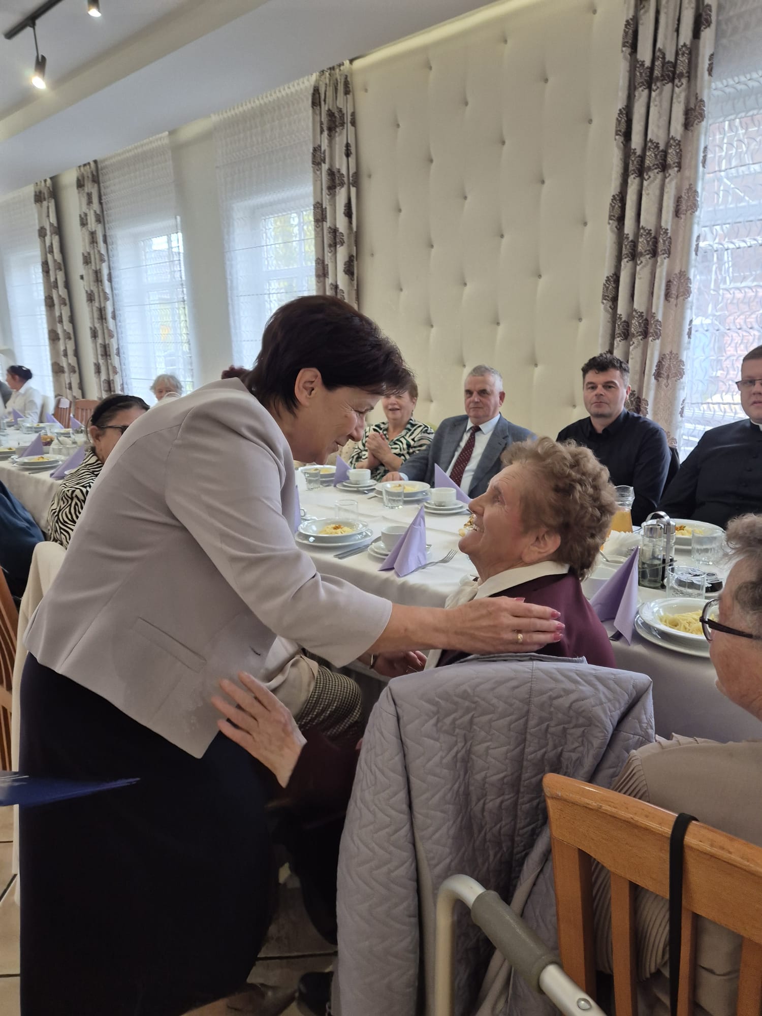 Pani w&nbsp;szarej marynarce uściska pania