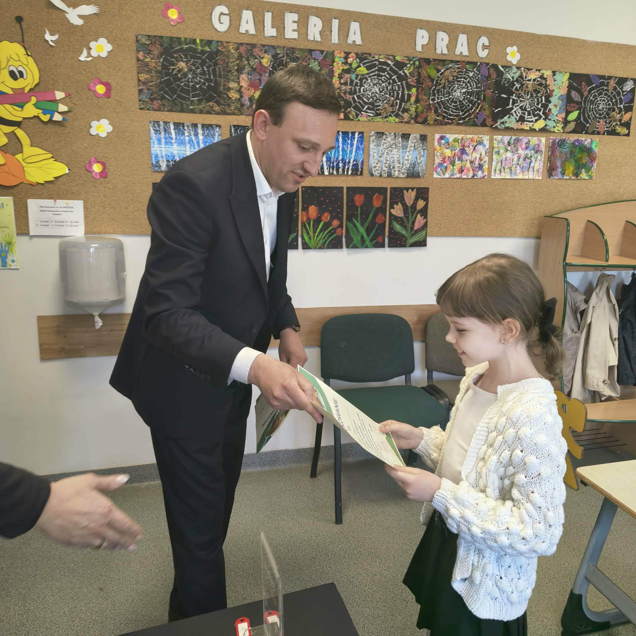 W&oacute;jt wręcza nagrodę dziewczynce w&nbsp;białym sweterku