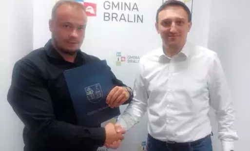 Mężczyzna w czarnej koszuli, obok mężczyzna w białej koszuli